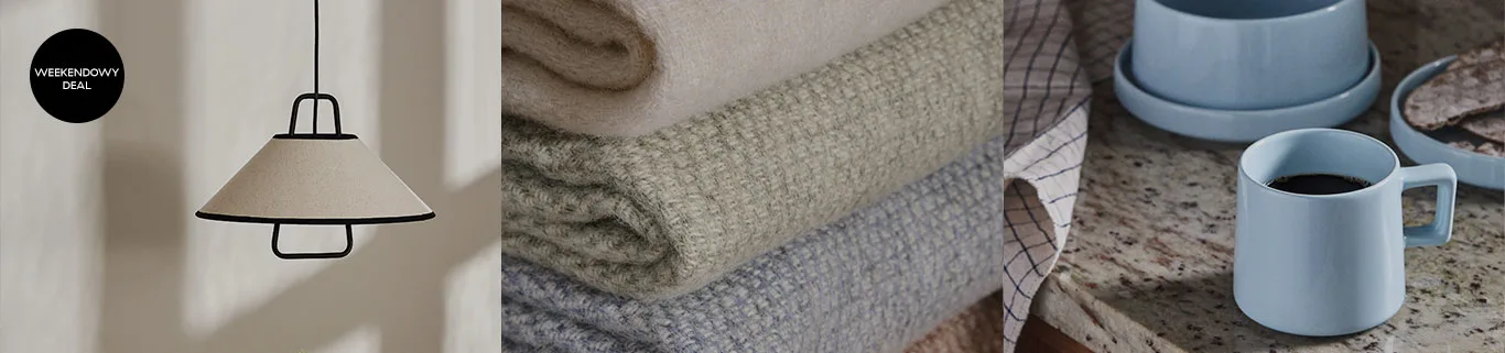 Beżowa lampa wisząca, ułożone koce dzianinowe w kolorach beżowym, zielonym, niebieskim i jasnoniebieski kubek na kawę na blacie.