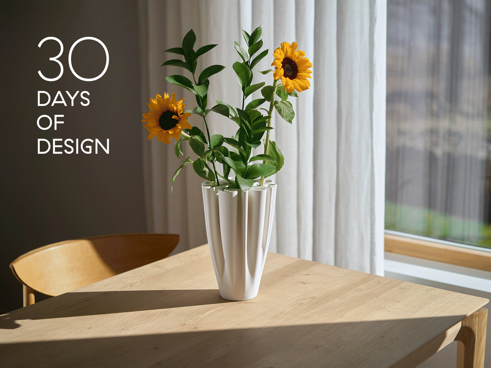 Biały plisowany wazon ze słonecznikami na drewnianym stole. Tekst brzmi '30 DAYS OF DESIGN'.
