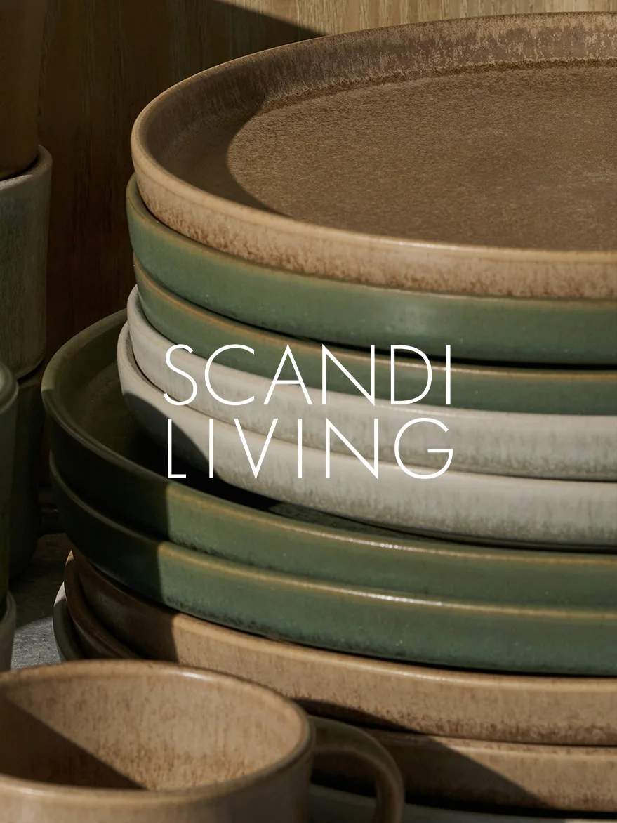 Ułożone w stos ceramiczne talerze w odcieniach ziemi z kubkiem, z napisem 'SCANDI LIVING'.