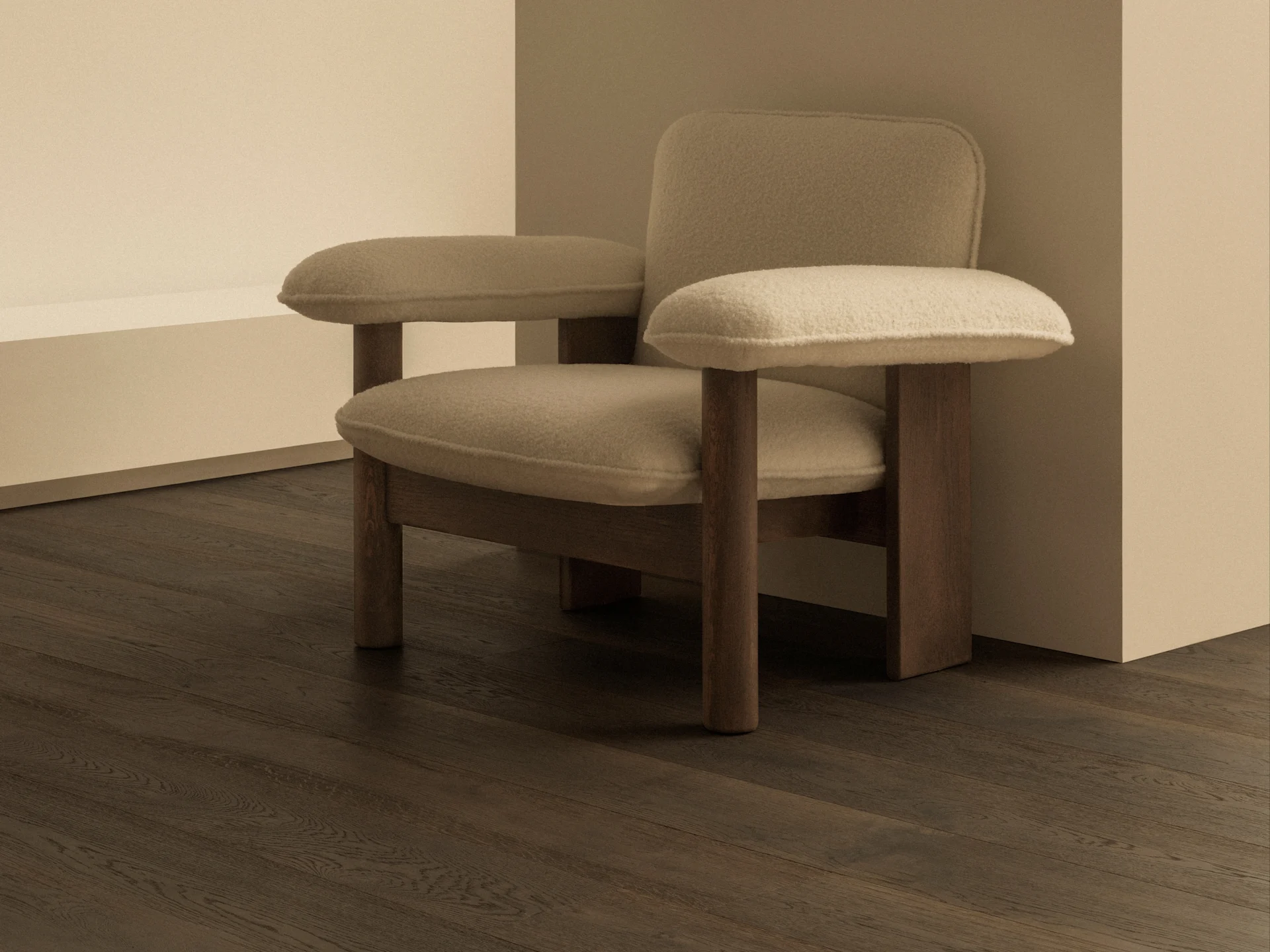 Minimalistyczne pomieszczenie z beżowym fotelem tapicerowanym, ciemnymi drewnianymi podłogami i nowoczesną mosiężną lampą ścienną z białą kulą.